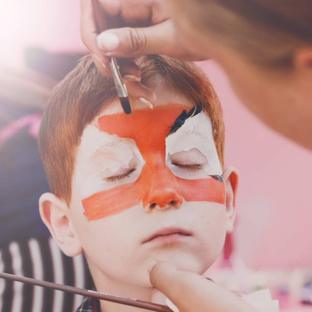 istock Child boy face painting, making tiger eyes process 866498810