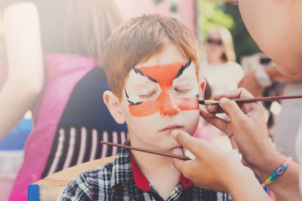 istock Child boy face painting, making tiger eyes process 866498864