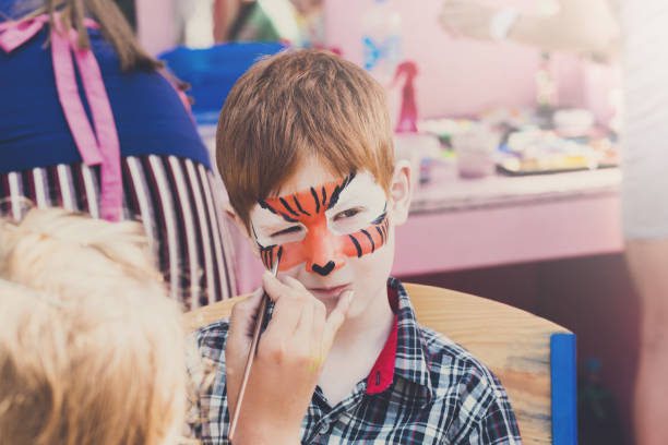 istock Child boy face painting, making tiger eyes process 866502772