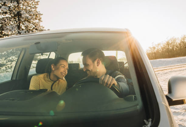 istock Young smiling couple talking while traveling by car during winter day. 866507142
