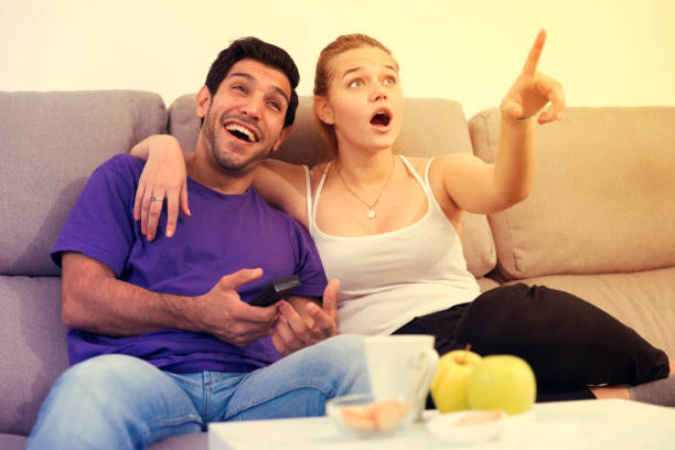 istock Happy couple watching TV at home 866515628