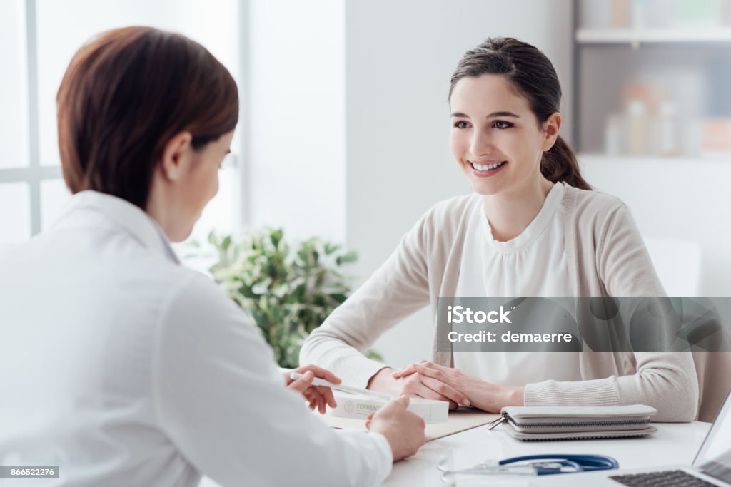 Doctor giving a prescription medicine Smiling patient in the doctor's office, she is receiving a prescription medicine Doctor Stock Photo