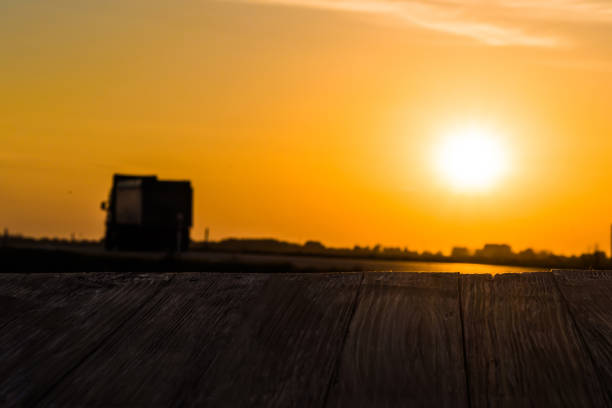 istock Empty rustic wood table top with motion blurred truck at sunset background. Can montage or display your products 866526548
