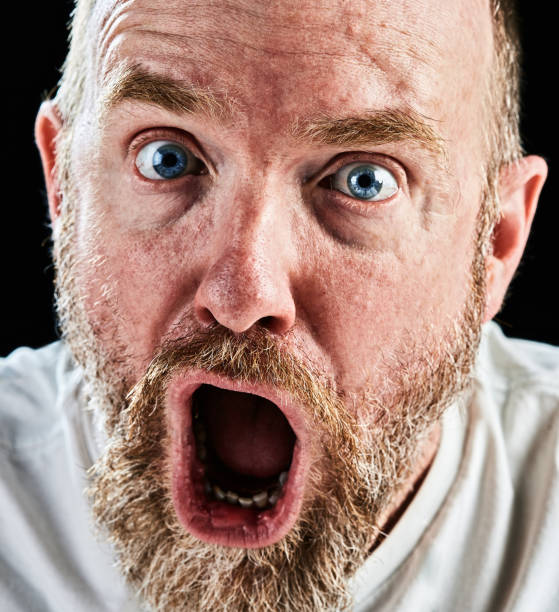 istock Mature bearded man looks at camera open mouthed and shocked 866527582