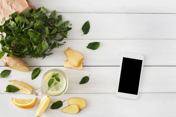 istock Detox lemonade smoothie ingredients, top view on white with smartphone 866530422