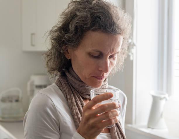 istock Middle aged woman holding glass in kitchen 866530768