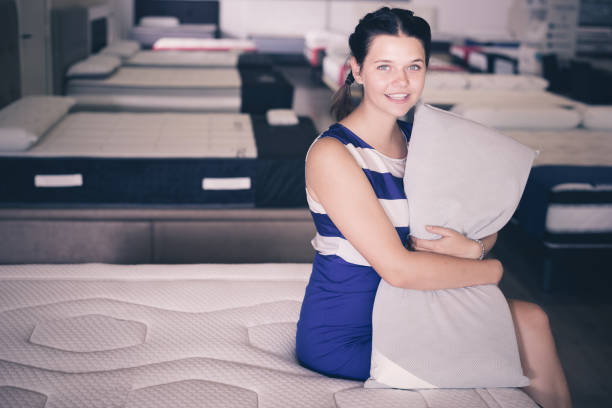 istock Female sitting with pillow on mattress 866534368