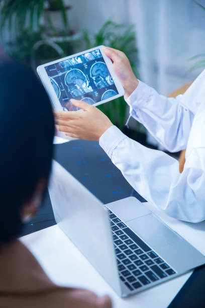 istock Doctor and patient discussing X-ray on digital tablet 866534924