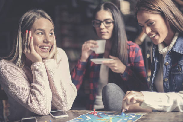 istock Cheerful three happy girls playing board game. 866538344