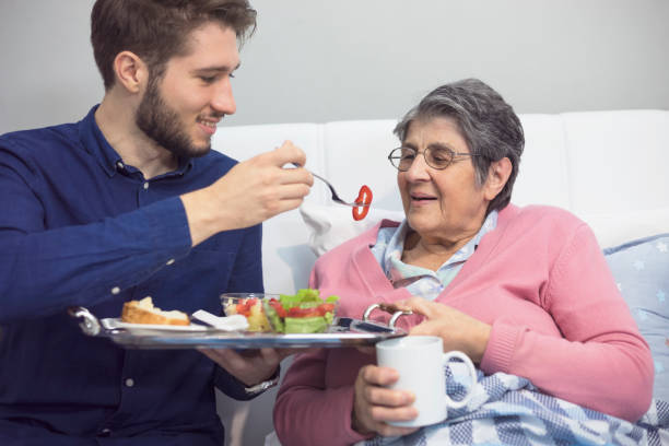 helping to the elderly - senior adult nursing home eating home interior imagens e fotografias de stock