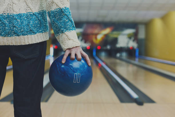 man holds ball at bowling lane, cropped image - boliche de dez paus imagens e fotografias de stock