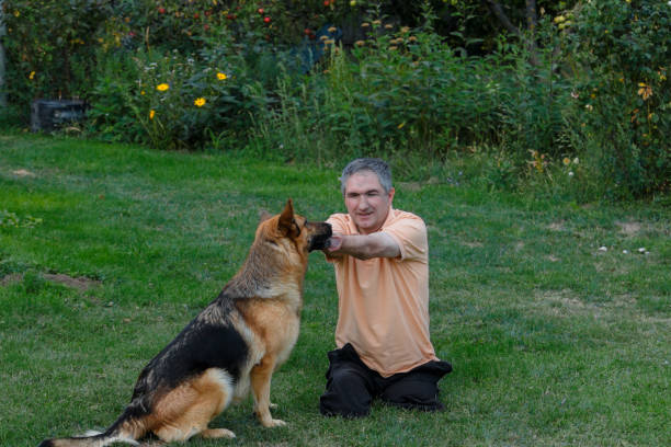 istock Disabled person is sitting on the grass and playing with a dog. 866540876