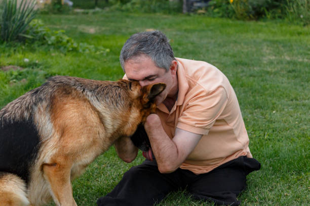 istock Disabled person is sitting on the grass and playing with a dog. 866540950