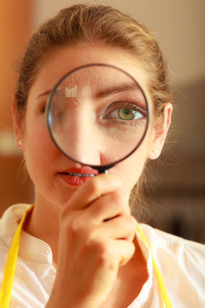 istock Woman looking through magnifying glass. 866543590