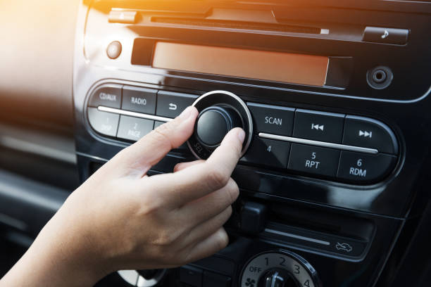 Woman turning button of radio in car Women turning button on car radio for listening to music radio stock pictures, royalty-free photos & images