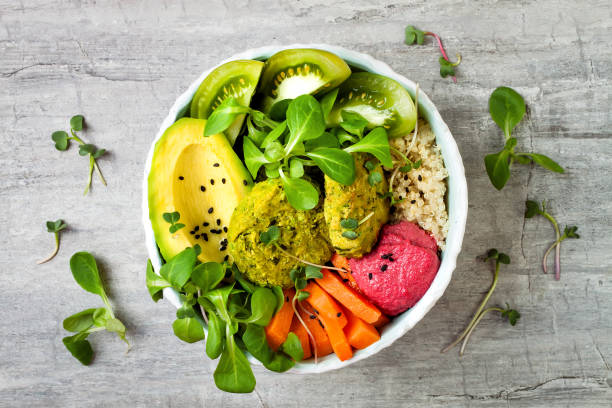 istock Middle eastern style Buddha bowl with green falafel, quinoa, butternut squash, tomatoes, avocado, beetroot hummus, micro greens and tahini sauce. 866556256