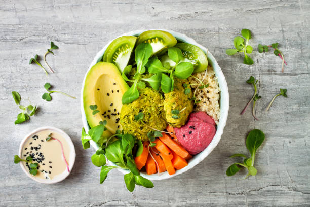 istock Middle eastern style Buddha bowl with green falafel, quinoa, butternut squash, tomatoes, avocado, beetroot hummus, micro greens and tahini sauce. 866556262