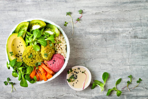 istock Middle eastern style Buddha bowl with green falafel, quinoa, butternut squash, tomatoes, avocado, beetroot hummus, micro greens and tahini sauce. 866556302