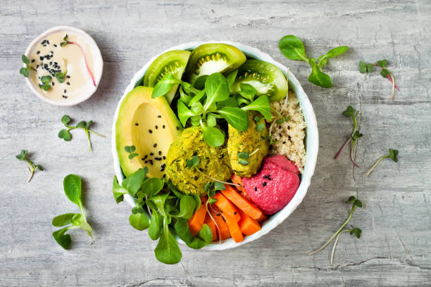 istock Middle eastern style Buddha bowl with green falafel, quinoa, butternut squash, tomatoes, avocado, beetroot hummus, micro greens and tahini sauce. 866556306