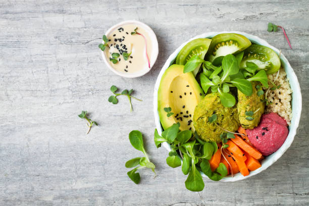 istock Middle eastern style Buddha bowl with green falafel, quinoa, butternut squash, tomatoes, avocado, beetroot hummus, micro greens and tahini sauce. 866556338