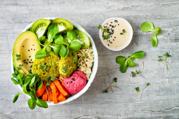 istock Middle eastern style Buddha bowl with green falafel, quinoa, butternut squash, tomatoes, avocado, beetroot hummus, micro greens and tahini sauce. 866556352