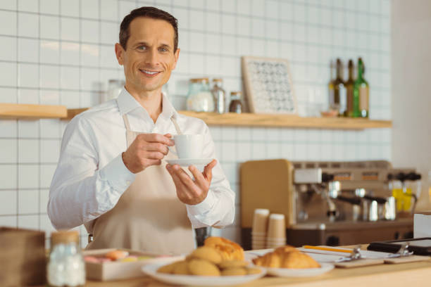 istock Delighted positive man holding a cup of coffee 866556536