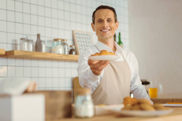 istock Positive delighted man holding a plate with croissants 866557438