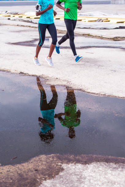Low section view of two young African American friends jogging in urban environment