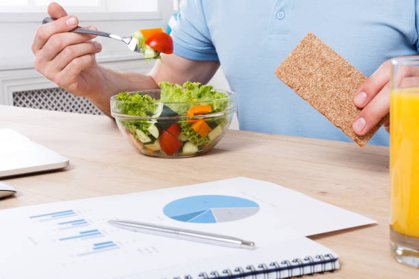istock Unrecognizable man has healthy business lunch in modern office interior 866568018