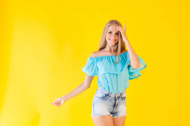 istock beautiful blonde with blue eyes posing on a yellow background 866571202