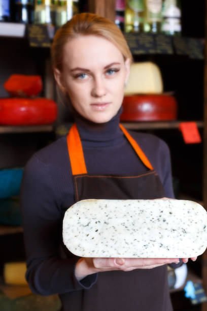 istock Gouda cheese in shop assistant hands 866578412