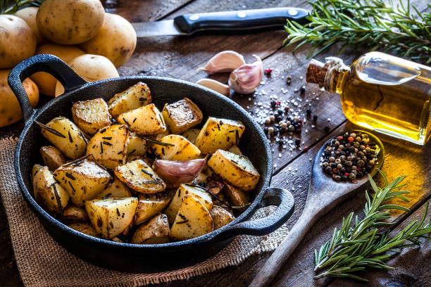 bratkartoffeln auf holz küchentisch - roasted potatoes prepared potato herb food stock-fotos und bilder