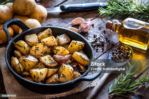 Roasted Potatoes On Wooden Kitchen Table Stock Photo - Download Image Now - Raw Potato, Prepared Potato, Roasted Potatoes
