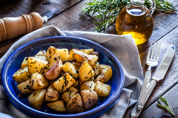 istock Roasted potatoes in a blue plate on wooden kitchen table 866584988