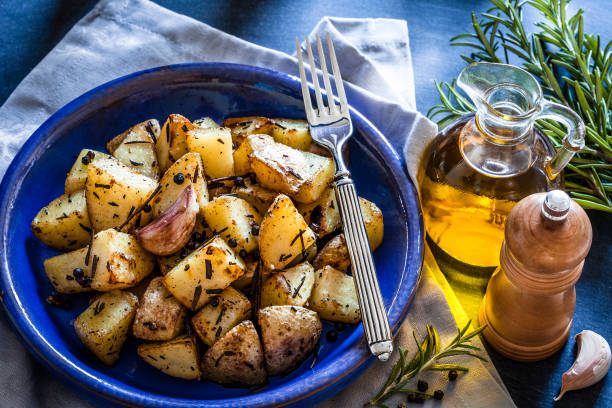 istock Roasted potatoes in a blue plate on wooden kitchen table 866585108