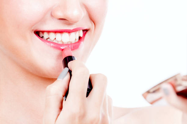 istock Woman paints lips with lipstick on white background 866588400