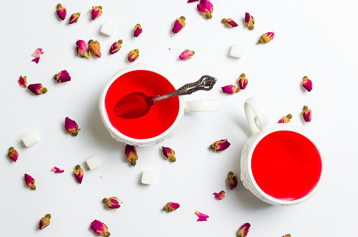 Rose tea in cups with flowers  on white background