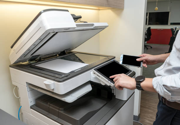Man copying paper from Photocopier by his smartphone using Near-field communication technology
