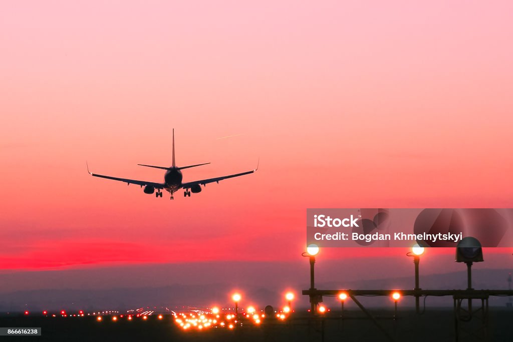 Avión aterriza en un campo de aviación en la puesta del sol - Foto de stock de Avión libre de derechos