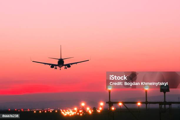 Plane Lands At An Airfield At The Sunset Stock Photo - Download Image Now - Airplane, Airport, Commercial Airplane