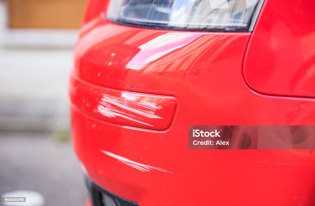 Damaged bumper of red car, traffic accident Red car bumper damage. Scratched Stock Photo