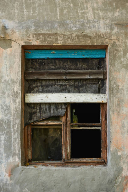 istock The old dirty broken window on the old dirty wall with cracks. 866626394