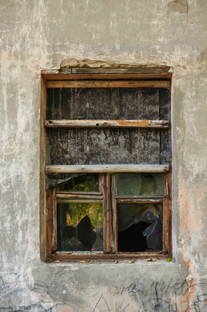 istock The old dirty broken window on the old dirty wall with cracks. 866626578
