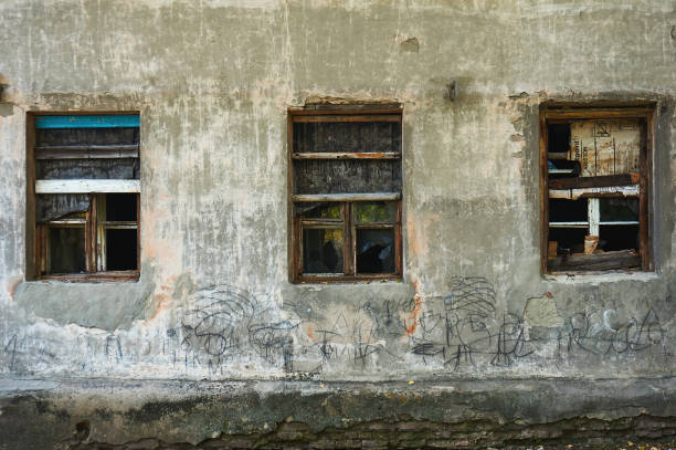 istock The old dirty broken window on the old dirty wall with cracks. 866626742