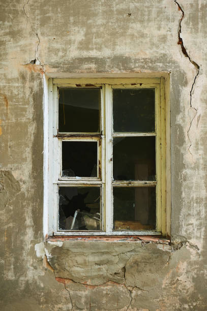 istock The old dirty broken window on the old dirty wall with cracks. 866626778