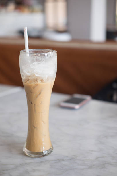 istock Ice coffee in a tall glass on stone table at coffee shop 866626802