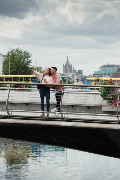 jeune couple sur banc à dublin - photographing smart phone friendship photo messaging photos et images de collection