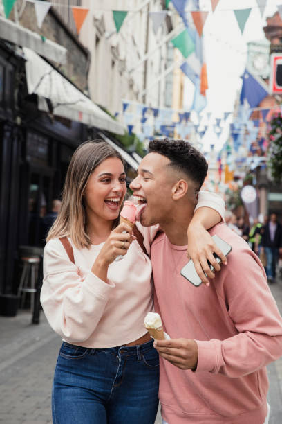 Couple eating ice-cream in Dublin A young couple eating ice cream in a Dublin street teen romance stock pictures, royalty-free photos & images
