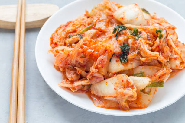 istock Kimchi cabbage. Korean appetizer on white plate, horizontal, closeup 866635972
