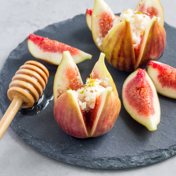istock Figs, cheese, pistachio and honey dessert on slate plate, square format 866636018